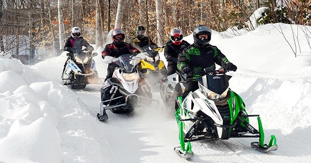 group of snowmobilers trail riding